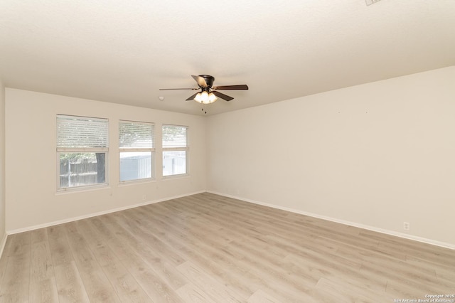 unfurnished room featuring light wood-style flooring, a ceiling fan, and baseboards