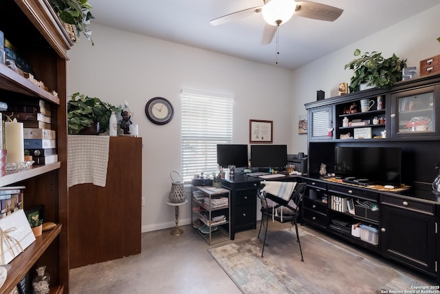 office with baseboards, concrete floors, and a ceiling fan