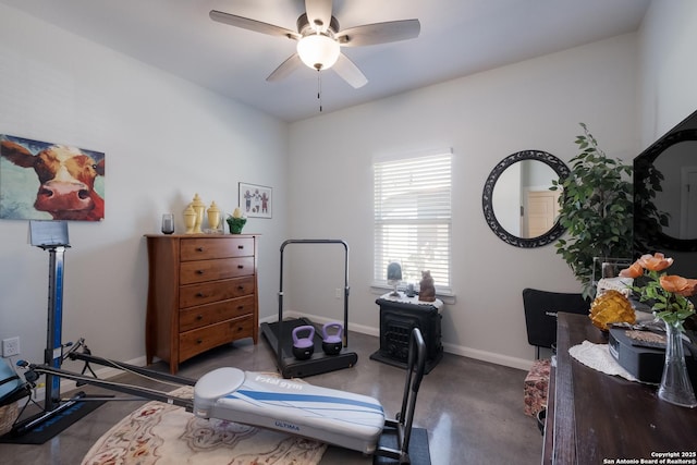 exercise room with baseboards and ceiling fan