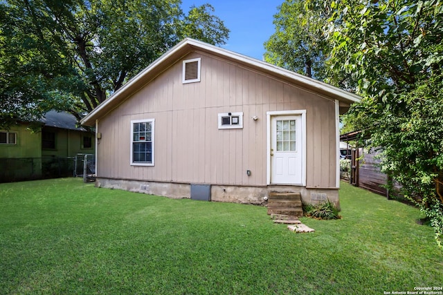 back of property with a yard, fence, and entry steps