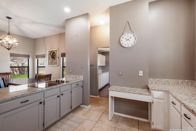 kitchen with light tile patterned floors, an inviting chandelier, a peninsula, decorative light fixtures, and black electric cooktop