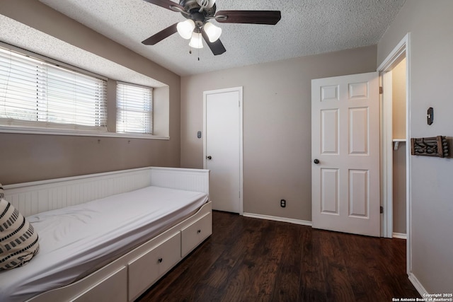 bedroom with baseboards, a textured ceiling, ceiling fan, and dark wood-style flooring