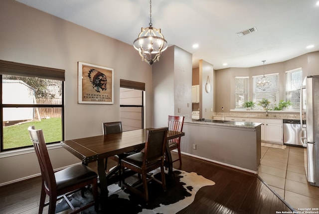 dining area featuring a chandelier, visible vents, and a wealth of natural light