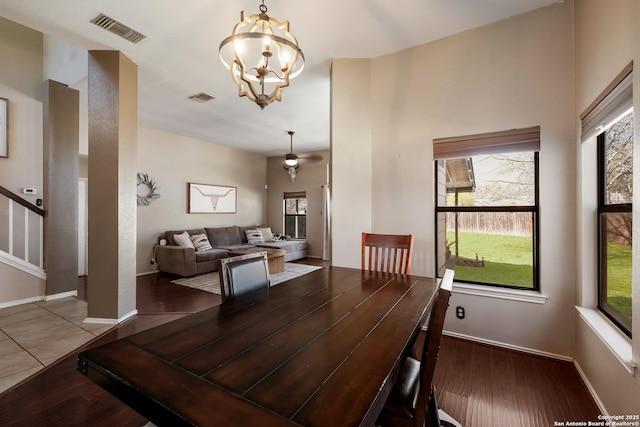 dining space with visible vents, wood finished floors, an inviting chandelier, baseboards, and stairs