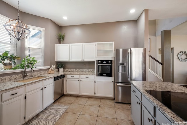 kitchen with white cabinetry, hanging light fixtures, appliances with stainless steel finishes, and a sink