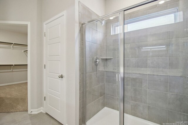 11583 Cottage Pt, San Antonio, TX 78254 - full bathroom with a shower stall, baseboards, tile patterned flooring, and a walk in closet