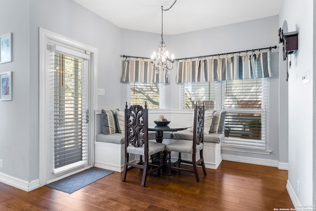 dining space featuring baseboards, wood-type flooring, and a chandelier