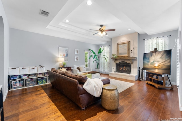 living area with visible vents, plenty of natural light, hardwood / wood-style floors, and a fireplace