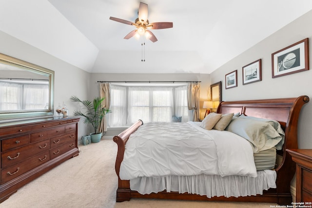 bedroom with light colored carpet, a ceiling fan, a tray ceiling, and lofted ceiling