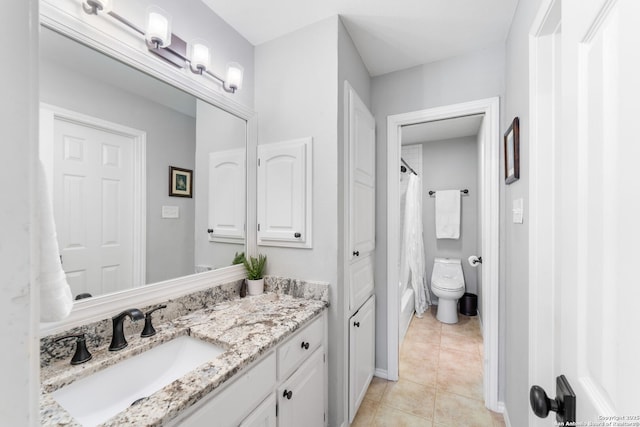 full bathroom with toilet, vanity, and tile patterned flooring