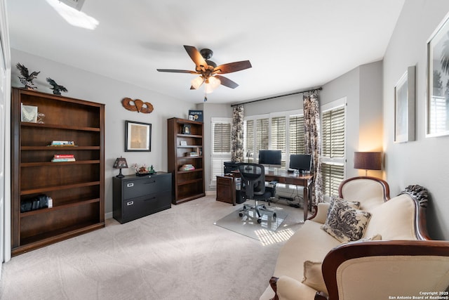 office space with light carpet and a ceiling fan