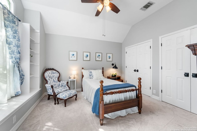 carpeted bedroom with visible vents, lofted ceiling, baseboards, and a ceiling fan