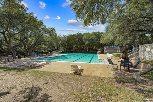 community pool with a patio and fence