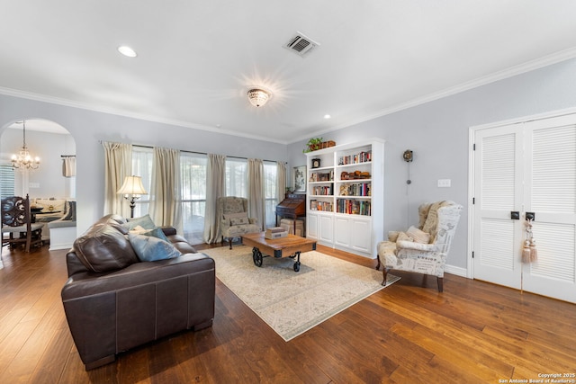 living area with visible vents, a chandelier, ornamental molding, arched walkways, and wood-type flooring