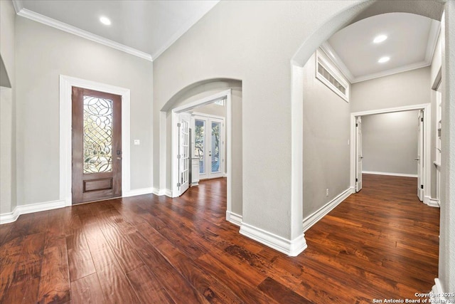 entrance foyer featuring hardwood / wood-style floors, arched walkways, and ornamental molding