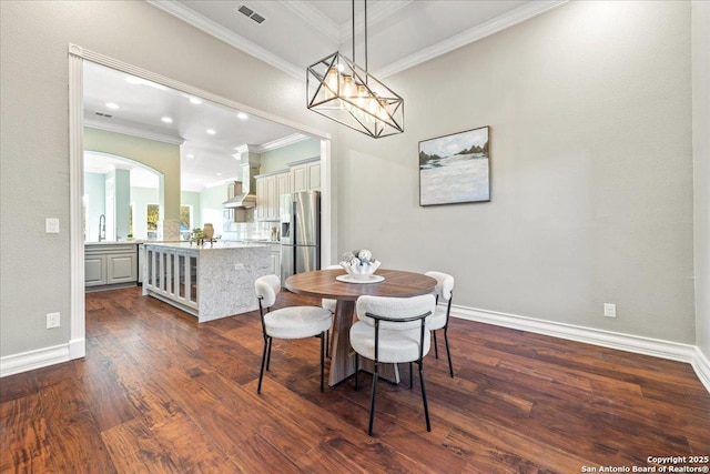 dining space with visible vents, dark wood-type flooring, arched walkways, crown molding, and baseboards