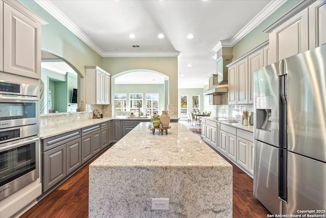 kitchen featuring backsplash, a kitchen island, appliances with stainless steel finishes, and gray cabinets