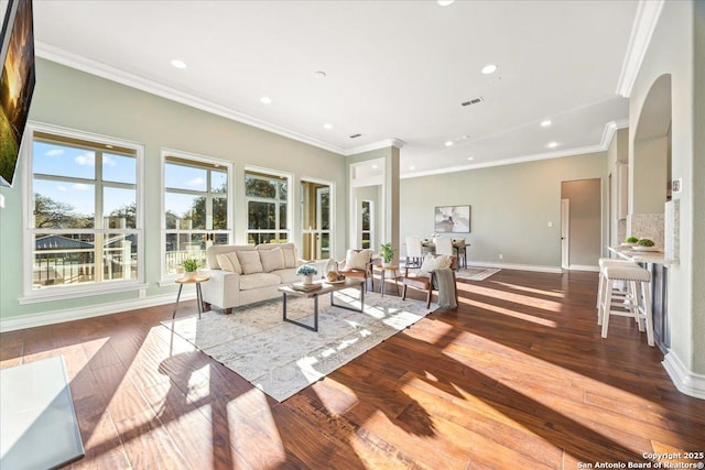 living area featuring hardwood / wood-style floors, crown molding, baseboards, and visible vents