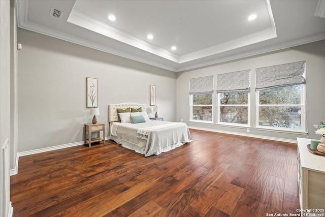 bedroom featuring visible vents, hardwood / wood-style floors, baseboards, crown molding, and a raised ceiling