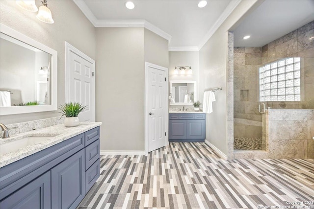 full bathroom with a shower stall, crown molding, baseboards, and a sink