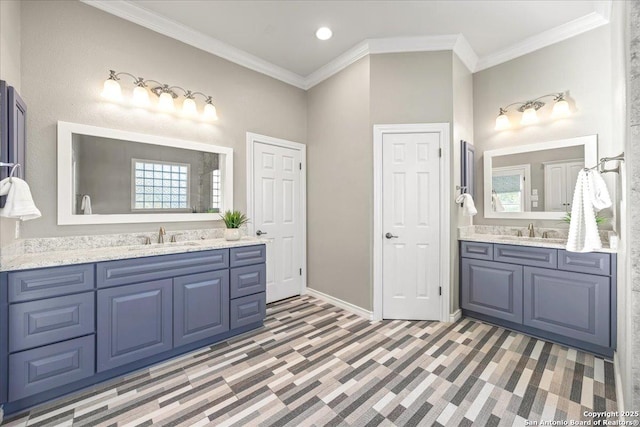 full bathroom featuring crown molding, two vanities, and a sink