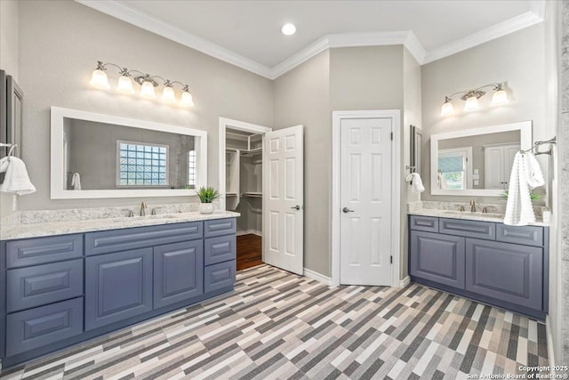 bathroom featuring a sink, two vanities, and crown molding