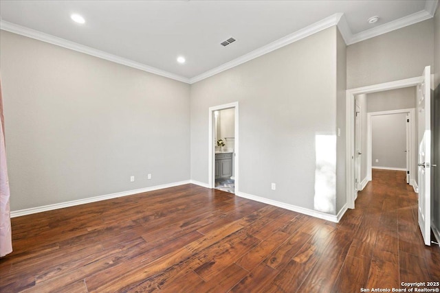 unfurnished bedroom with visible vents, baseboards, dark wood finished floors, and crown molding