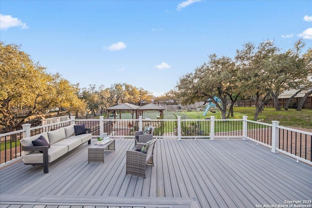 deck with an outdoor living space, fence, a lawn, and a playground