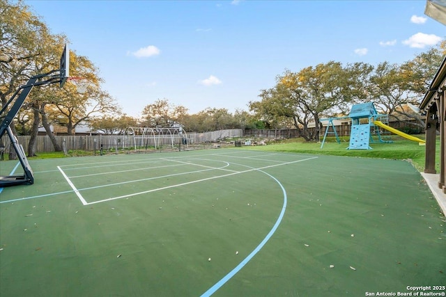 view of sport court featuring basketball hoop, a playground, a yard, and fence