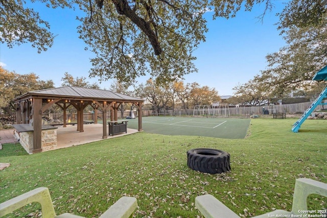 view of yard featuring a gazebo, fence, playground community, and central AC