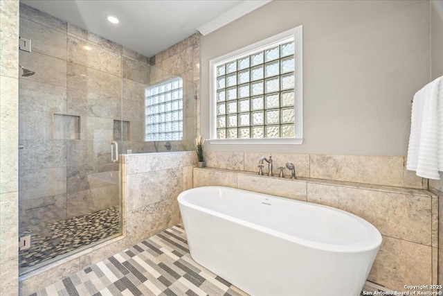 bathroom with tile walls, a soaking tub, recessed lighting, and a stall shower