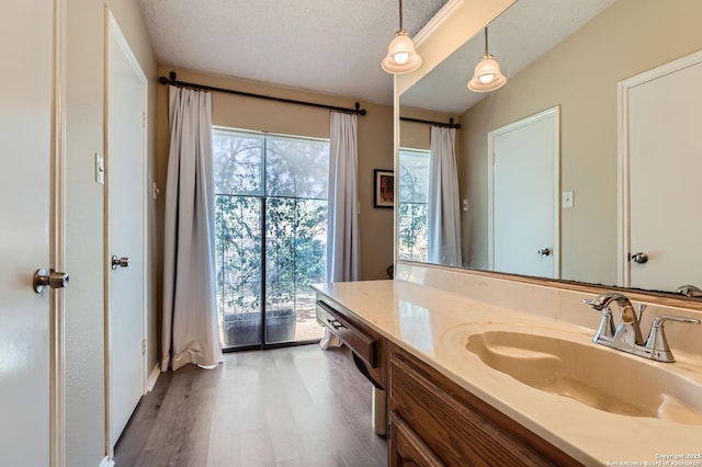 bathroom featuring a wealth of natural light, a textured ceiling, wood finished floors, and vanity