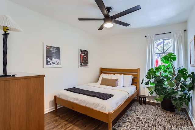 bedroom with a ceiling fan, baseboards, and wood finished floors