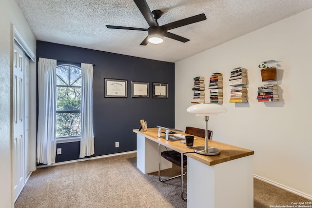 carpeted office with baseboards, a textured ceiling, and ceiling fan