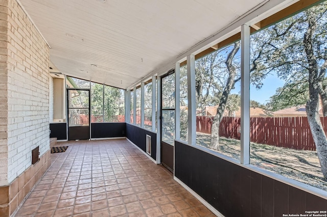 unfurnished sunroom with lofted ceiling