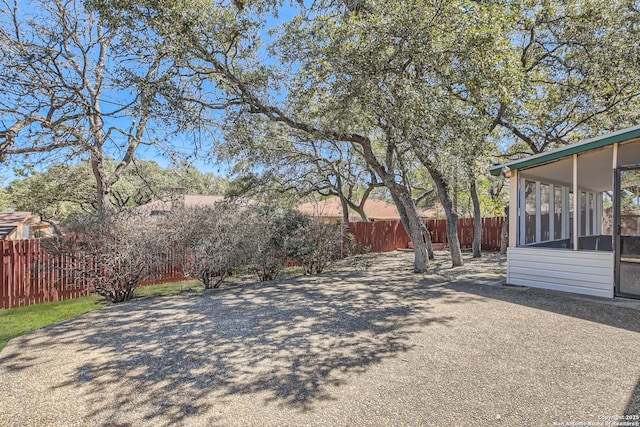 view of yard with a fenced backyard and a sunroom