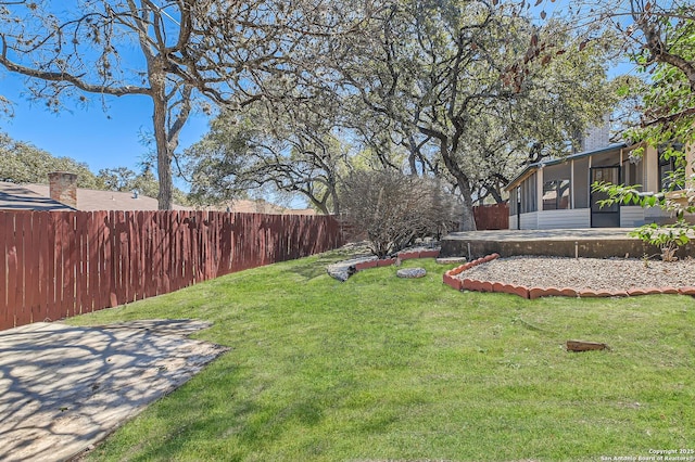 view of yard with a fenced backyard and a sunroom