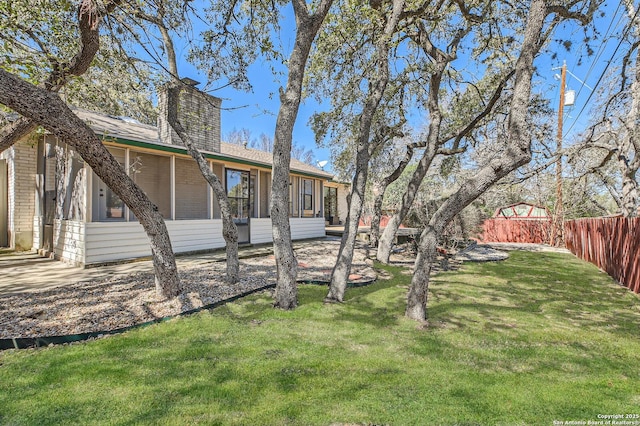 view of yard featuring fence and a sunroom