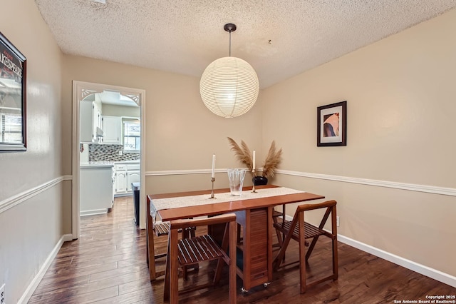 dining area featuring baseboards, a textured ceiling, and dark wood-style flooring