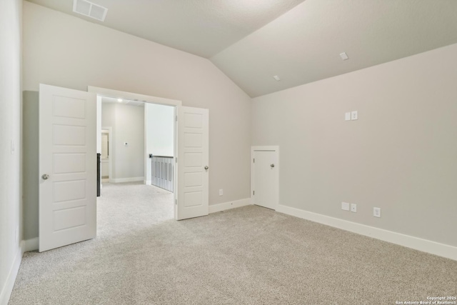 spare room with lofted ceiling, baseboards, visible vents, and carpet floors