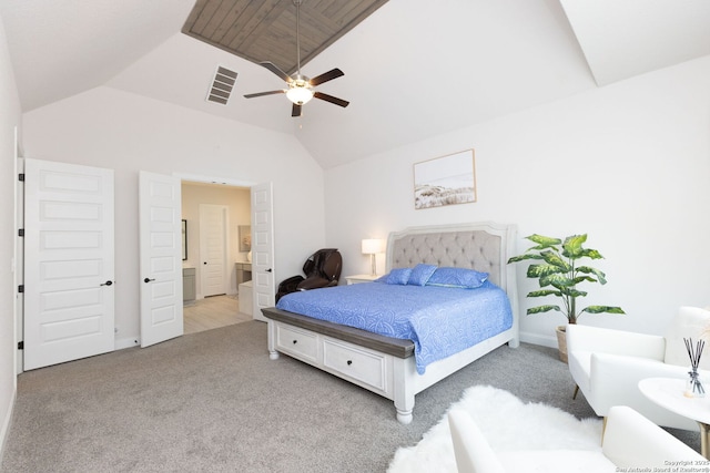 bedroom featuring visible vents, light carpet, ensuite bath, and vaulted ceiling