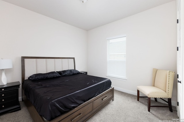 bedroom with baseboards and light colored carpet