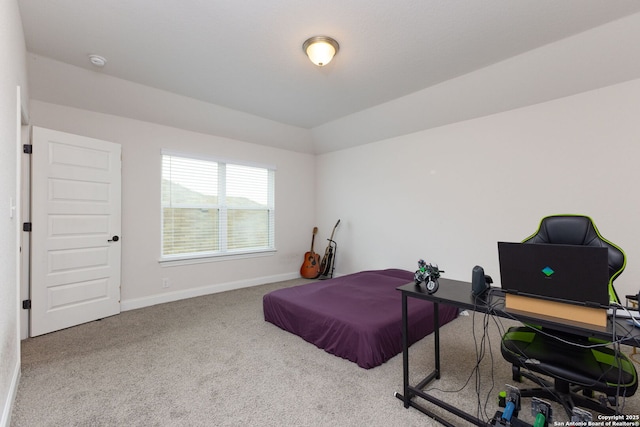 carpeted bedroom featuring lofted ceiling and baseboards