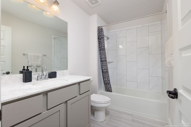 bathroom with visible vents, toilet, vanity, and shower / bath combo