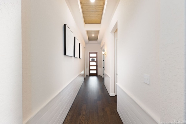 hall with dark wood finished floors and wainscoting