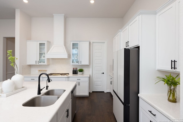 kitchen featuring white cabinetry, freestanding refrigerator, and a sink