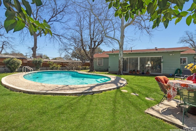 view of swimming pool with a patio area, a lawn, a fenced in pool, and fence