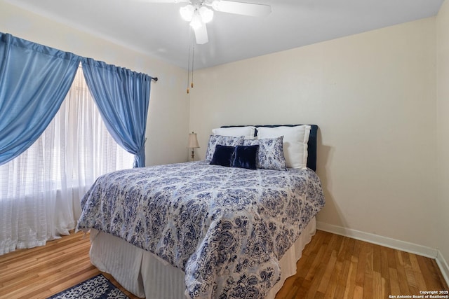 bedroom featuring a ceiling fan, wood finished floors, and baseboards