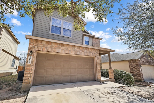 traditional-style home with an attached garage, brick siding, and central AC