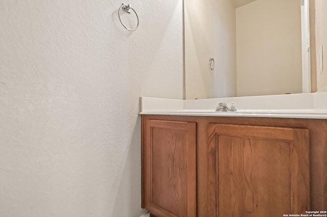 bathroom with vanity and a textured wall